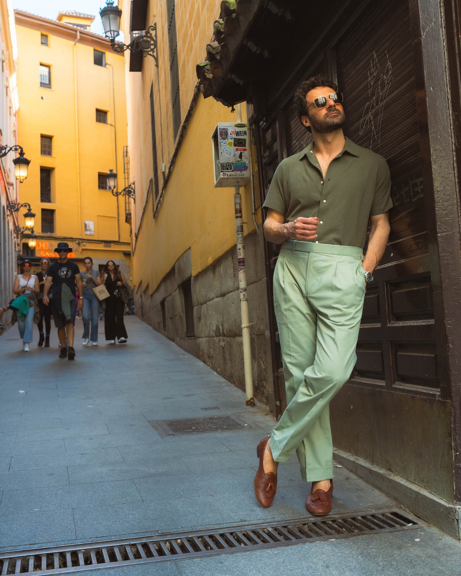 Model outside wearing the custom oxford polo shirt for men by Luxire in olive green hand in pocket 2