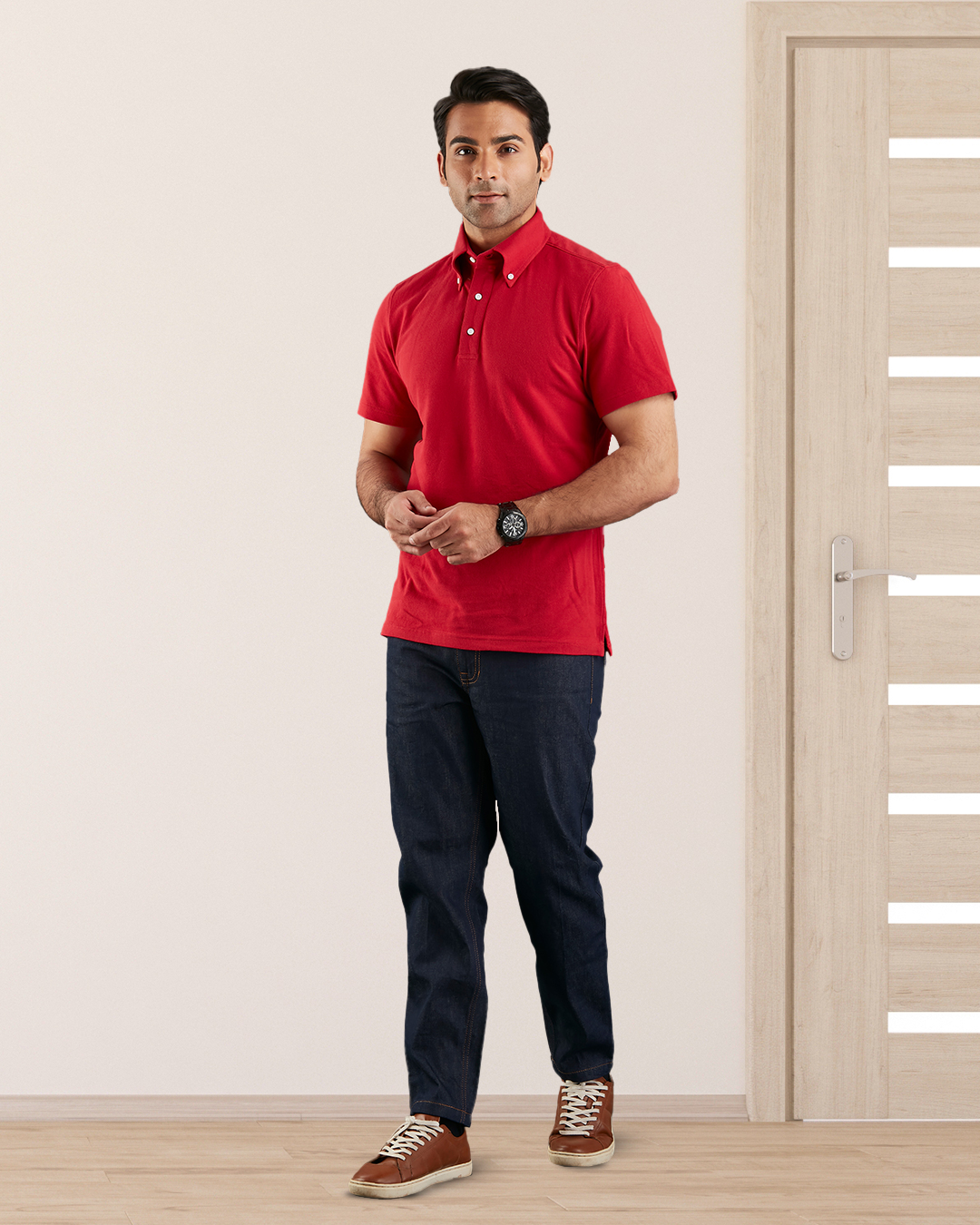 Model wearing the custom oxford polo shirt for men by Luxire in red hands together 3