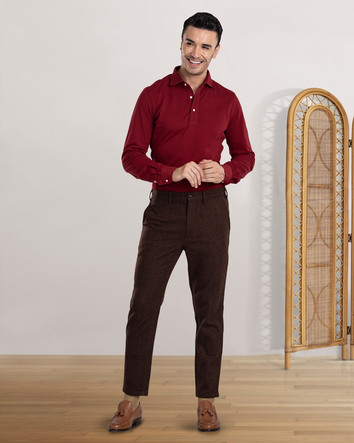 Model wearing the custom oxford polo shirt for men by Luxire in maroon hands together