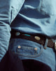 Close up of model wearing mens fade washed jeans by Luxire in indigo 2