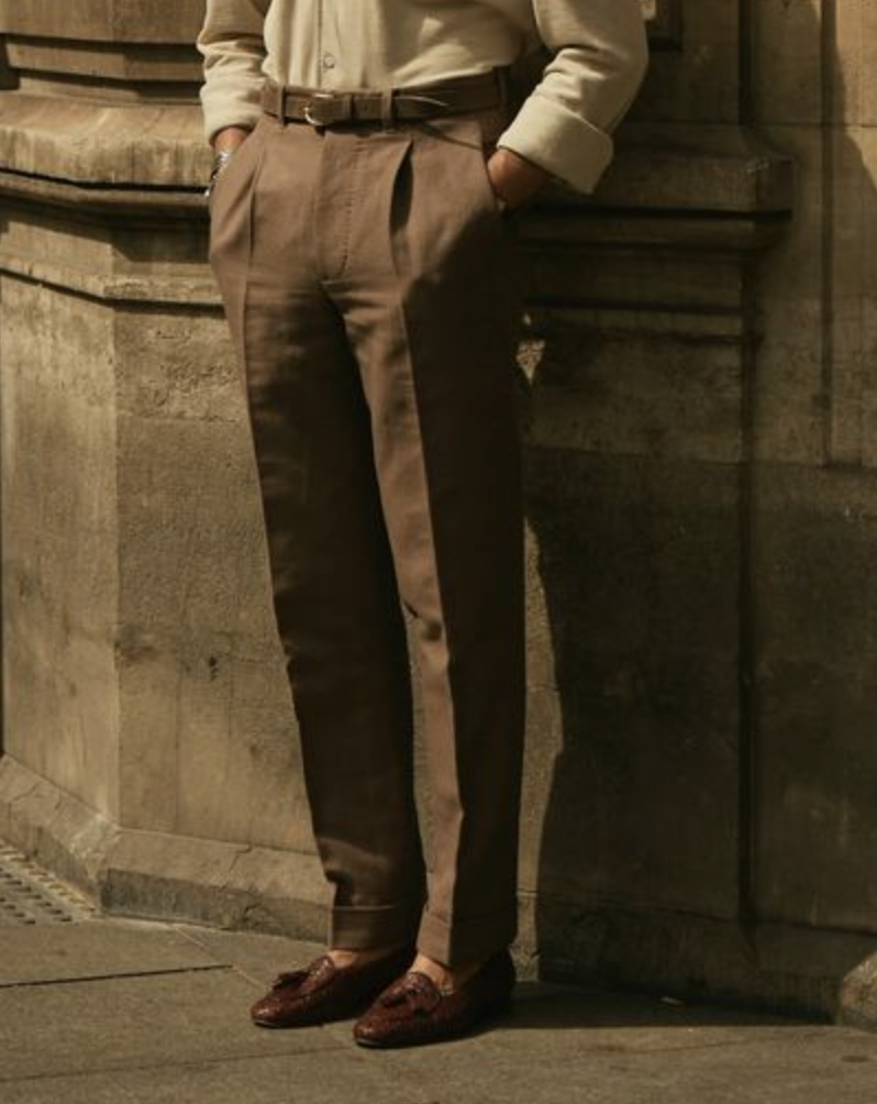 Model wearing custom linen canvas pleated pants for men by Luxire in brown