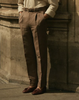 Model wearing custom linen canvas pleated pants for men by Luxire in brown