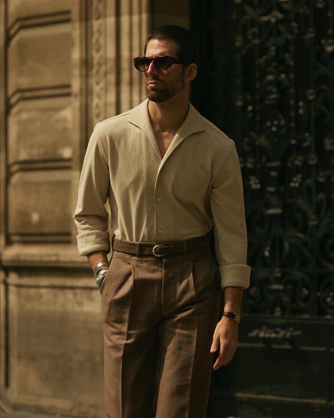Model with hands in pockets wearing custom linen canvas pleated pants for men by Luxire in brown