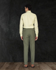 Back pose of male model wearing custom linen canvas pants for men by Luxire in olive green