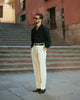 Model in front of stairs wearing custom linen Gurkha pants for men by Luxire in cream