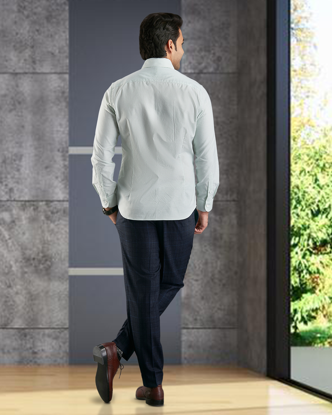 Back of model wearing the custom oxford shirt for men by Luxire in shades of green hands in pockets