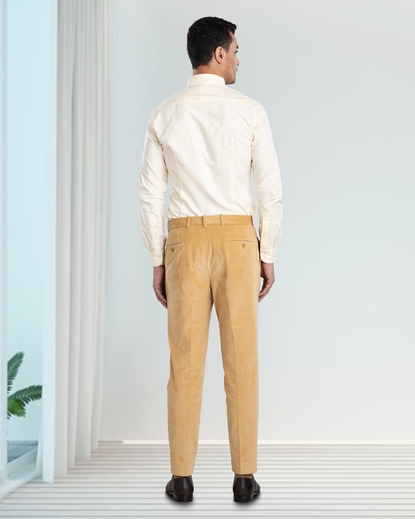 Back of model wearing the custom oxford shirt for men by Luxire in pale yellow hand in pocket