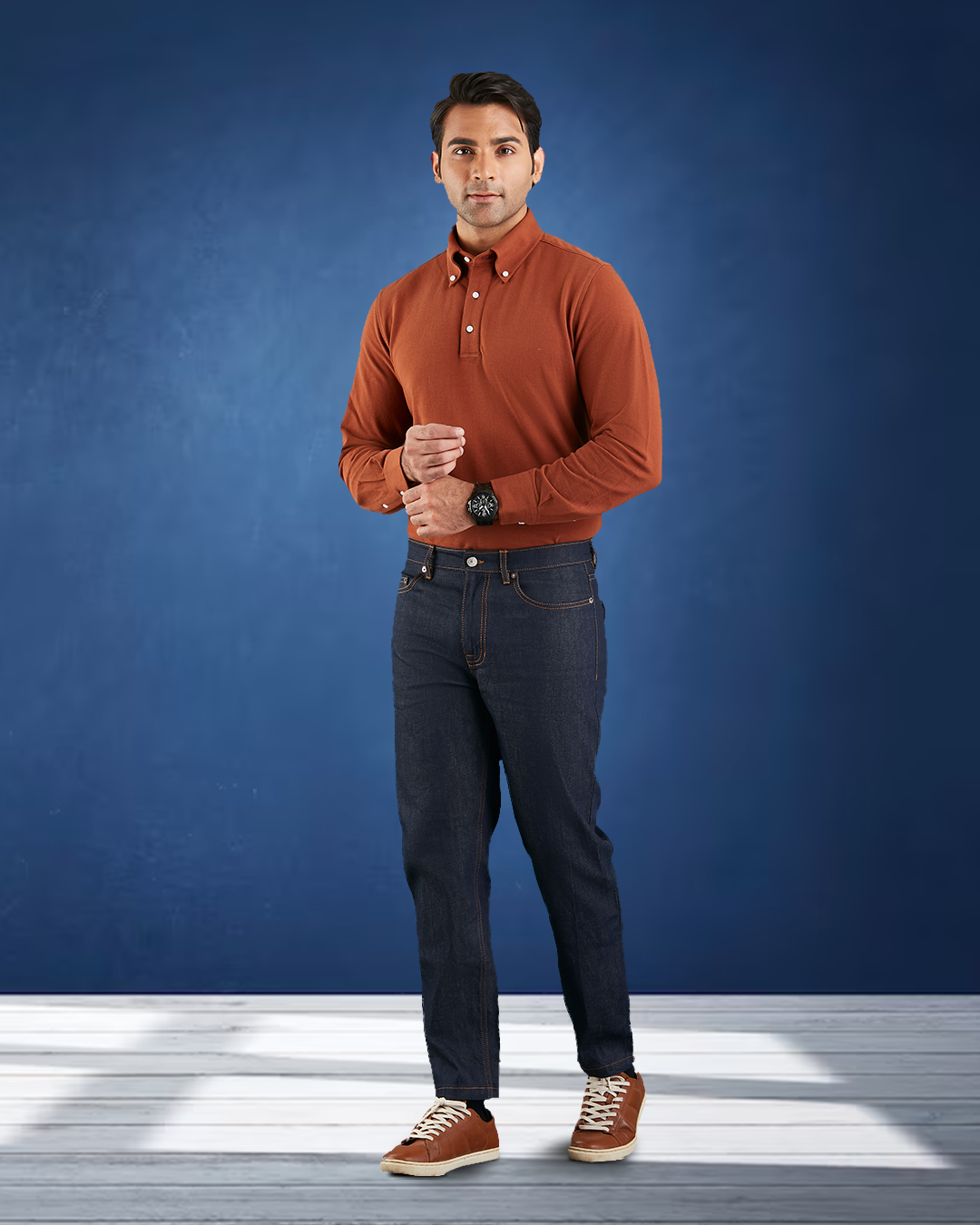 Model wearing the custom oxford polo shirt for men by Luxire in copper hands together 2