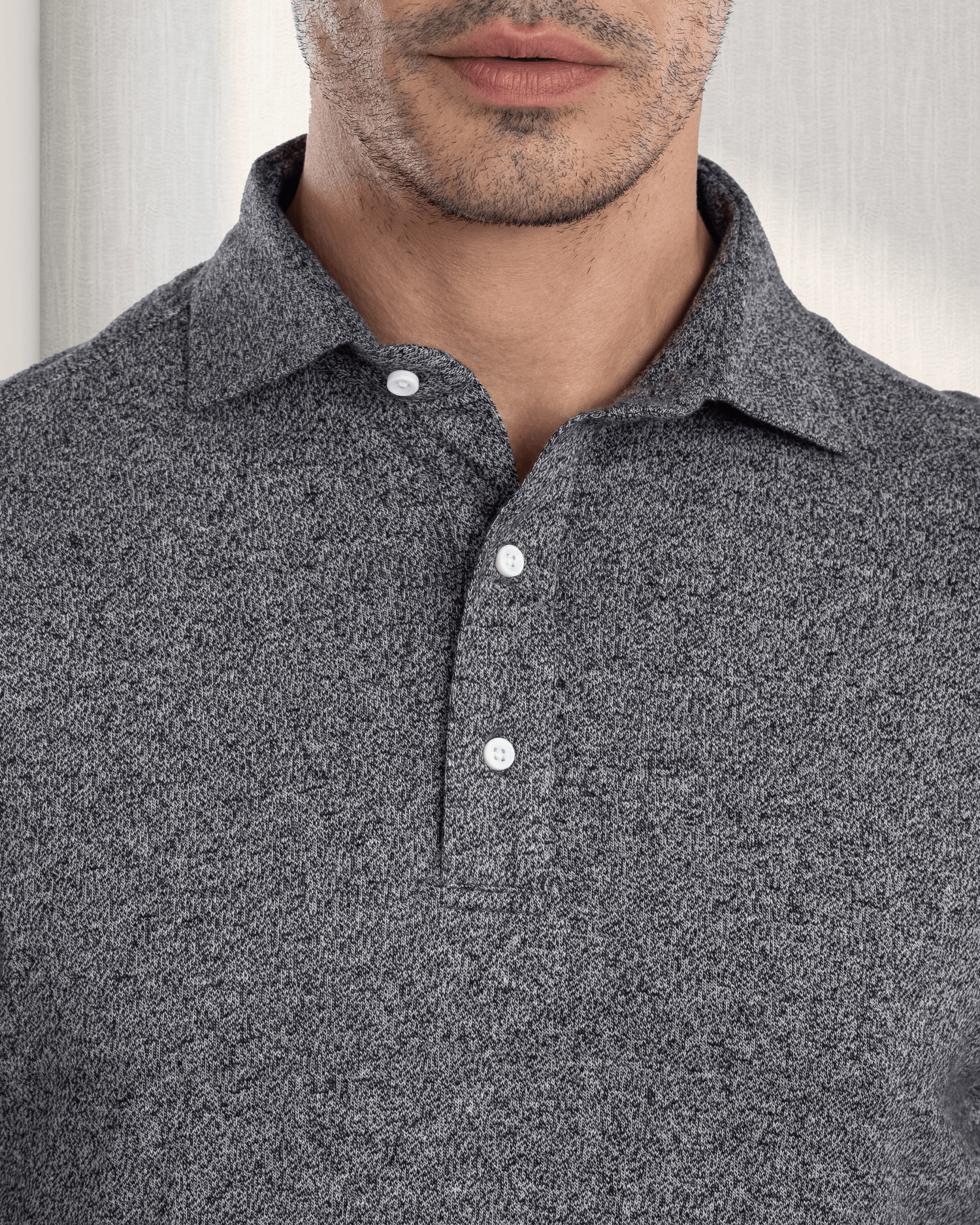Close up of model wearing the custom oxford polo shirt for men by Luxire in dark light grey