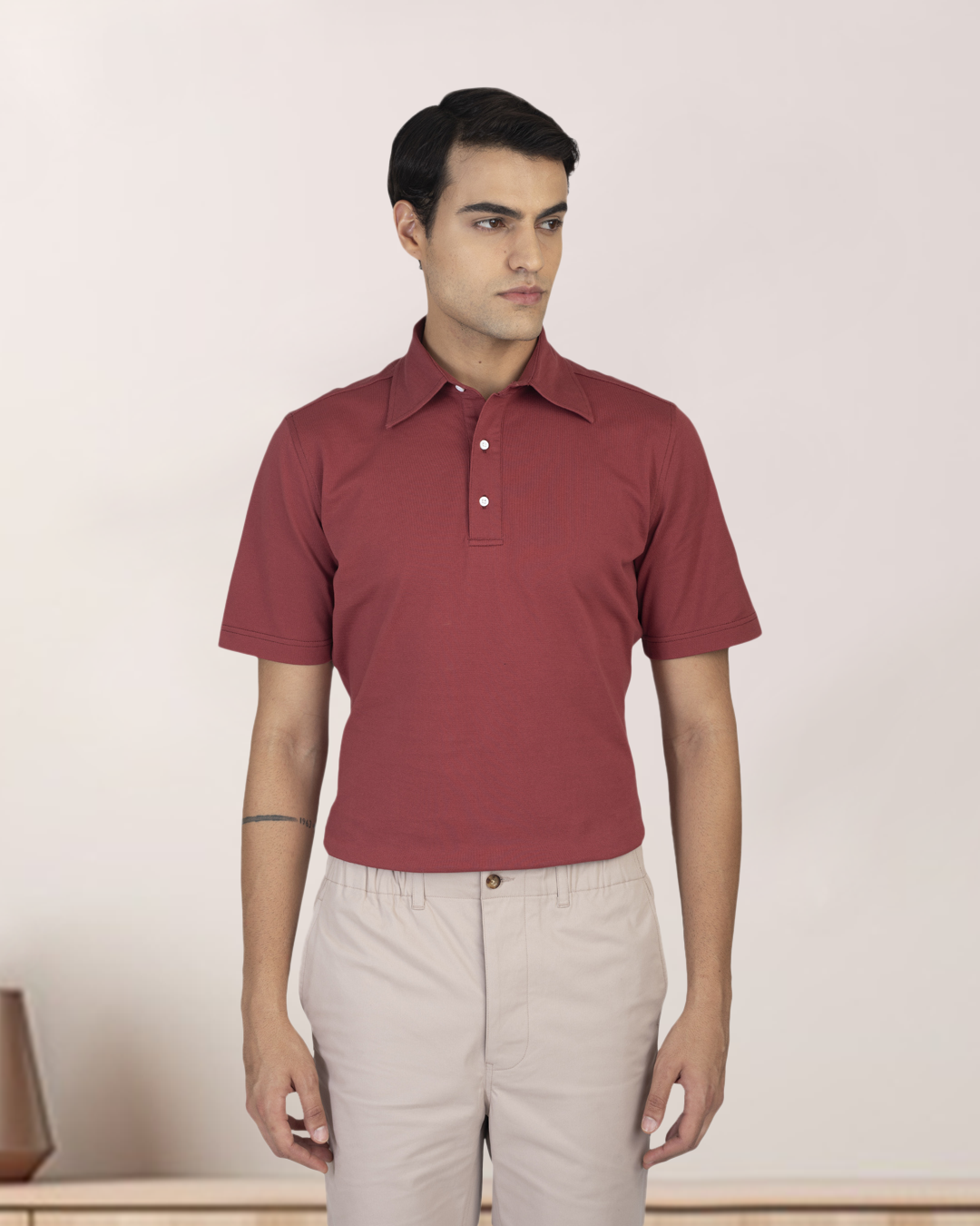 Front of model wearing the custom oxford polo shirt for men by Luxire in soft marsala hands at side