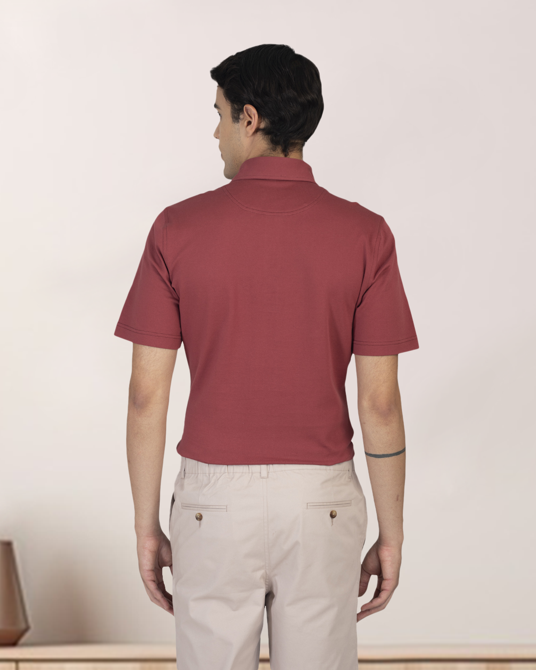 Back of model wearing the custom oxford polo shirt for men by Luxire in soft marsala