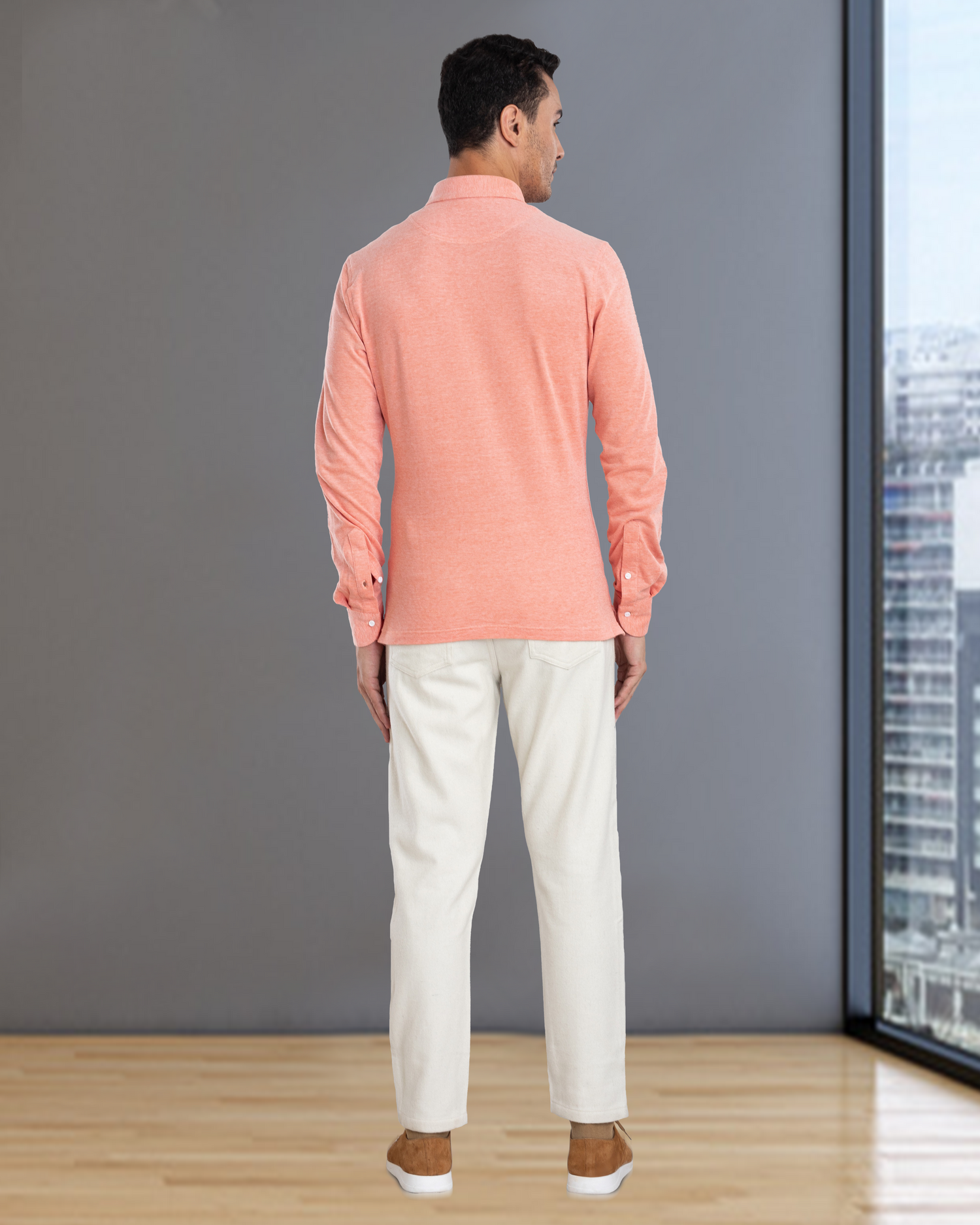 Back of model wearing the custom oxford polo shirt for men by Luxire in orange white