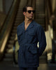 Model outside wearing the safari jacket in linen for men by Luxire in dark indigo hands in pockets