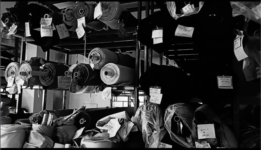 Luxire workshop — racks of labelled fabric rolls ready to be cut
